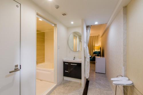 uma casa de banho com um lavatório e um chuveiro em Himalaya Cloud Hotel em Tóquio