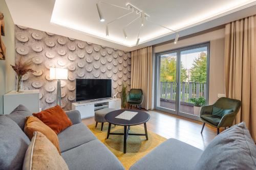 een woonkamer met een bank en een tv bij Rio de Mare - Nadmorze Apartments in Gdańsk