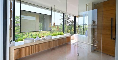 Munggu的住宿－Villa Nica by Elite Havens，一间带两个盥洗盆和大镜子的浴室