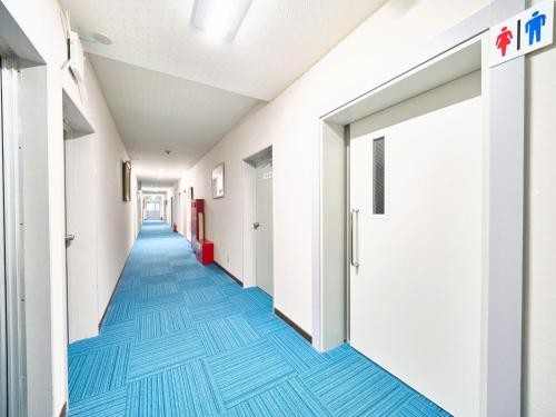 a corridor of an empty hospital hallway with blue floors at Okasan Hotel - Vacation STAY 77675v in Ogaki