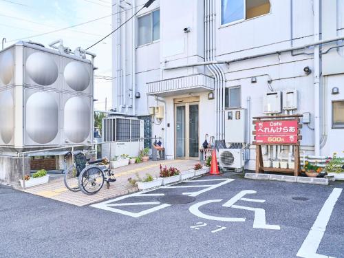 a bike parked in a parking lot in front of a building at Okasan Hotel - Vacation STAY 77675v in Ogaki