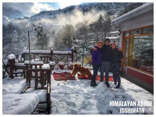 a group of people standing in the snow with a dog at Himalayan Abode Joshimath in Joshīmath