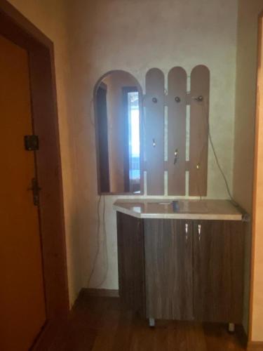 a bathroom with a sink and a mirror at Тихая теплая уютная однушка in Karagandy