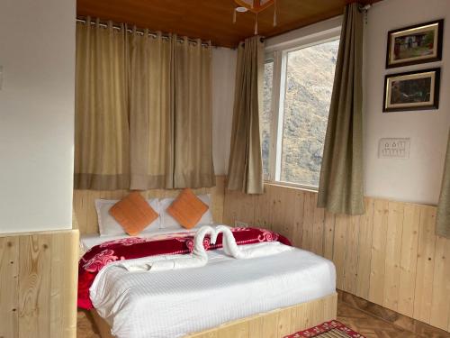 a bedroom with a large bed with a window at Himalayan Abode Joshimath in Joshīmath