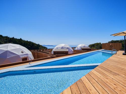 una piscina con cúpulas en la parte superior de una casa en Glamping Resort GLANSO NAGASAKI, en Nagasaki