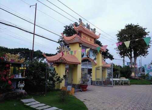 a small yellow building with flags in front of it at Ruby Motel Bà Rịa in Bà Rịa