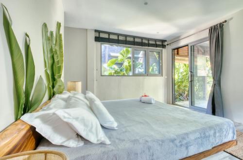 a bedroom with a large bed and a window at Kajali Siargao in General Luna