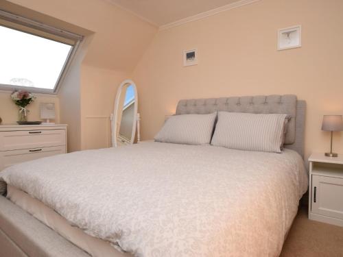 um quarto com uma grande cama branca e uma janela em 3 Bed in Melrose 76698 em Galashiels