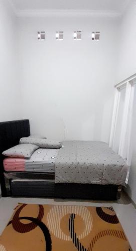 Duas camas individuais num quarto com um tapete em Villa Yanti Permata Garden F7 em Karangploso