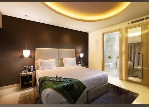 a bedroom with a large bed and a bathroom at AMAZNING VIEW & PARAMOUNT BRANDED TWO BEDROOM APARTMENTS BRUJ VIEW in Dubai