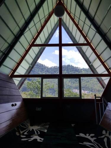 a room with a large window in a roof at Villa Songgokerto Batu in Songgoriti