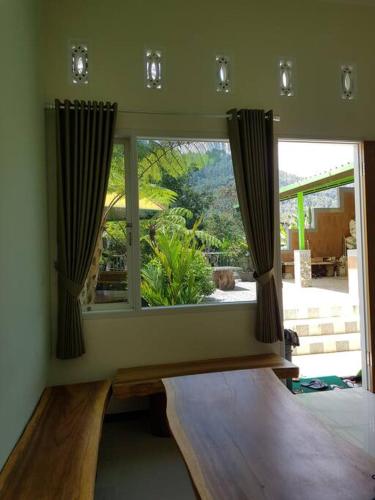 a bedroom with a window with a view of a garden at Villa Songgokerto Batu in Songgoriti