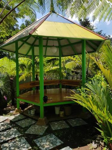 a gazebo with a roof in a garden at Villa Songgokerto Batu in Songgoriti