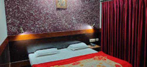 a bedroom with a bed and a red curtain at Hotel Ajay International Agra in Agra