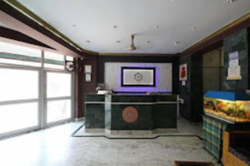 Hotel Ajay International Agra في آغْرا: غرفة معيشة مع تلفزيون على الحائط