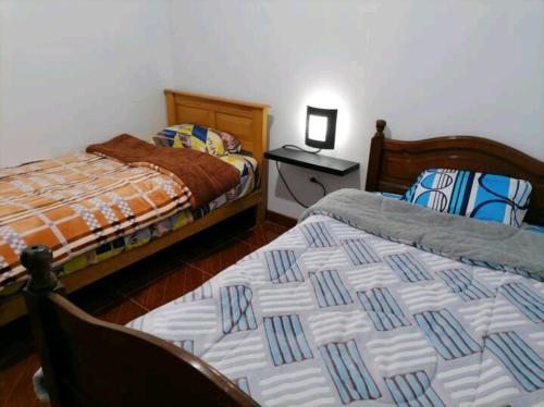 ein Schlafzimmer mit 2 Betten und einem Tisch mit einem Nachttisch in der Unterkunft Departamento-Bolognesi B1 in Chiclayo