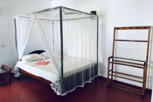 1 dormitorio con cama con dosel y escalera en Ranmitha Villa, en Weligama