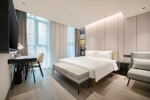 a bedroom with a large white bed and a desk at Atour Hotel Shanghai Lujiazui Pudong Avenue in Shanghai