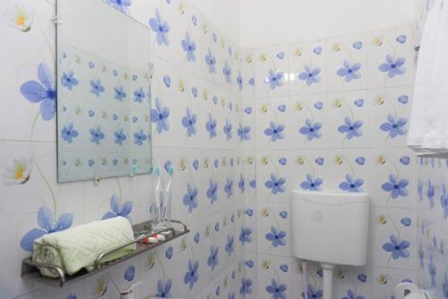 a bathroom with blue flowers on the wall at Hotel Victoria Inn (Nazimuddin Road) in Dhaka