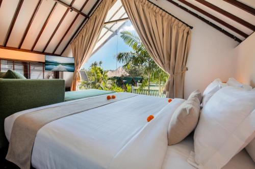 a bedroom with a large bed and a window at Villa Tramonto By Le Cielo in Canggu