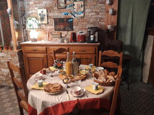 einen Tisch mit Speisen und Getränken darüber in der Unterkunft La Maison d'Andrée in Pluvet