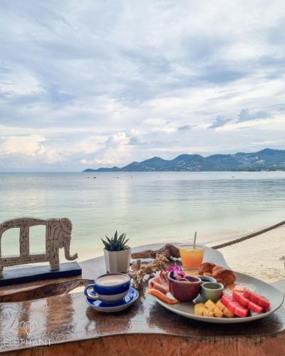 a tray of food on a table next to the beach at Elephant Beach Club & Resort Samui in Chaweng