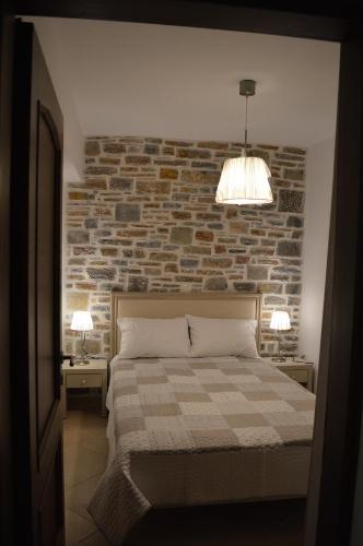 チョルトにあるAnais Apartmentsのレンガの壁とベッドが備わるベッドルーム1室が備わります。