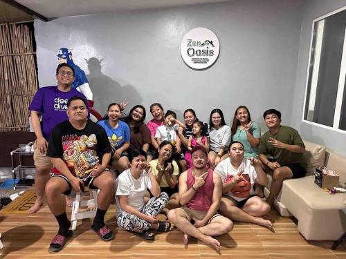 a group of people posing for a picture in a living room at Welcome to Our Farm House in Del Rosario