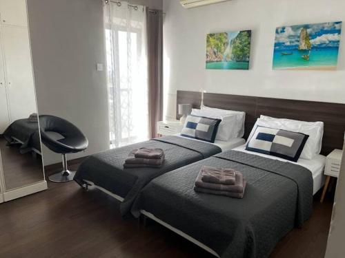 - une chambre avec 2 lits et une chaise dans l'établissement Apartment in Swieqi with communal pool, à Tal-Għoqod