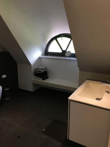 a small bathroom with a sink and a window at Reetdachhaus bei St Peter-Ording - Tating in Tating