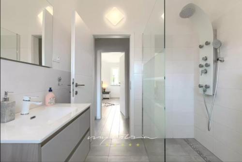 une salle de bain blanche avec une douche et un lavabo dans l'établissement Villa Sarah Medulin, à Medulin