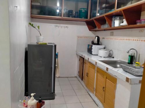 eine kleine Küche mit Spüle und Kühlschrank in der Unterkunft S&S Transient House-San Isidro Cabuyao in Cabuyao