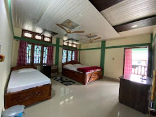 sypialnia z 2 łóżkami w pokoju w obiekcie Ninashi Homestay Wakro 