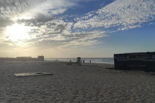a beach with a surfboard on the sand at Swan Nest in Alexandria