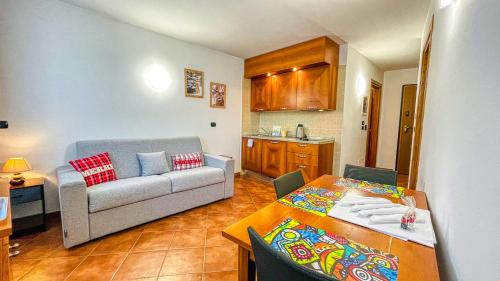 ein Wohnzimmer mit einem Sofa und einem Tisch in der Unterkunft Appartamento Smith Dogliani - Affitti Brevi Italia in Bardonecchia