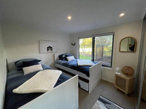 een slaapkamer met 2 bedden en een raam bij Self Contained Villa in Hawley Beach