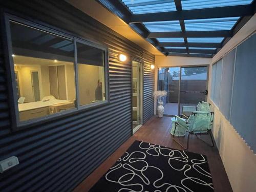 een kamer met een balkon met uitzicht op een badkamer bij Self Contained Villa in Hawley Beach
