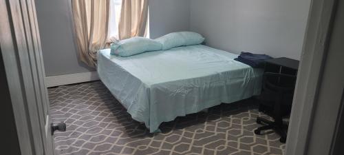 a small bed with a pillow on it in a room at Room in a Beach House with King Size bed in a landlord hosted three bedroom apartment in Edgemere