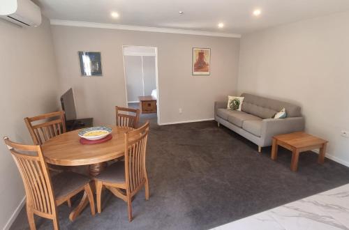 un soggiorno con tavolo e divano di Ravensdale Vista a Christchurch
