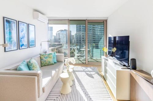 a living room with a couch and a large window at Brand New! Luxurious Sky Ala Moana 2 Bed 2 Bath in Honolulu