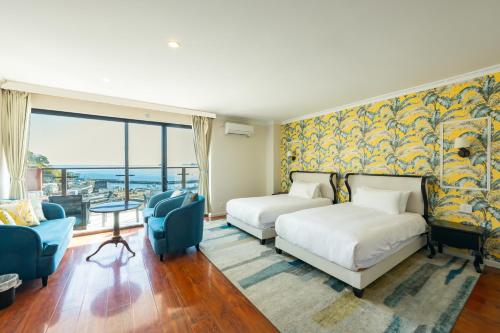 a hotel room with two beds and a couch at HOTEL HIMALAYA SEA in Ito