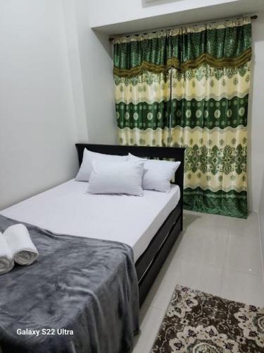 a bedroom with two beds and a window with curtains at Azul Condo 2 bedroom Manila in Manila