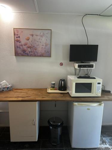 a desk with a microwave and a computer on it at Colosseum Creek Motel in Colosseum