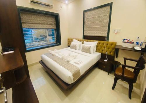 a bedroom with a bed with a desk and a chair at One Infinity Residency in kolkata