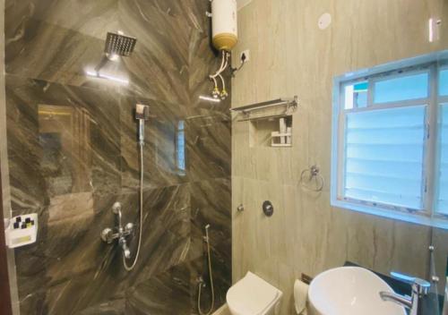 a bathroom with a shower and a toilet at One Infinity Residency in kolkata