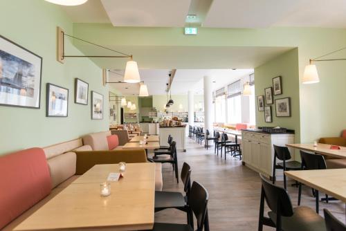 a restaurant with tables and chairs and a cafeteria at Hotel Stella Maris in Hamburg