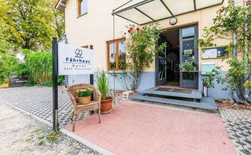 a sign in front of a building with plants at Hotel Fährhaus GmbH in Woltersdorf