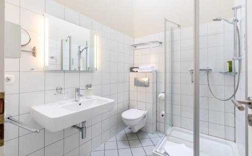 y baño con lavabo, aseo y ducha. en Hotel Fährhaus GmbH, en Woltersdorf