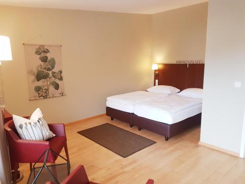 a small bedroom with a bed and a chair at Hotel Fährhaus GmbH in Woltersdorf