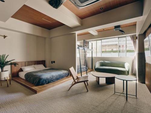 a bedroom with a bed and a couch and a table at illi Mani Shibuya in Tokyo